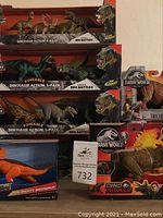 Image showing multiple boxed dinosaur figures including Jurassic World Triceratops and Sinoceratops, Dino Rivals Ceratosaurus, and various dinosaur action multi-packs.