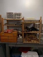 Shelves with plastic organizers, wooden chest, storage bin, metal easel parts, drafting tools