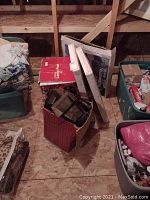 Photo shows five boxes containing various outdoor Christmas decorations and lighting pieces stored in an attic or storage area.