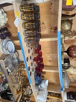 Overview of two glassware sets displayed on wooden shelving