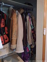 Closet hanging with five women's coats and muumuus, showing various textures and colors.