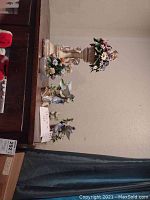 Five porcelain and ceramic figurines including two signed Capodimonte floral pieces and three made in Japan.