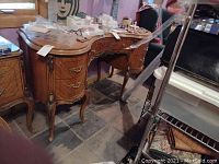 Front view of kidney-shaped dressing table with objects on top