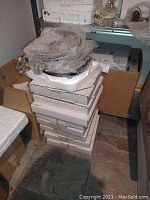 Stack of 19 white cardboard boxes with styrofoam packaging, containing collector plates.