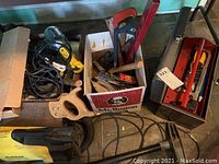 Image showing yellow Eureka The Boss vacuum alongside a box with saws and a Craftsman toolbox with hand tools