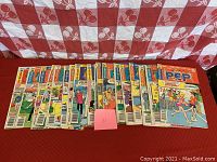 Row of 18 Archie Comics Pep issues laid out side by side on a red surface with a red and white checked backdrop.