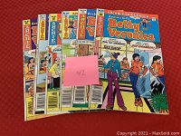 Six Betty and Veronica comic book issues fanned out on table showing front covers and issue numbers.