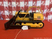 Side profile of the vintage Tonka T9 bulldozer showing original tracks, blade, and branding