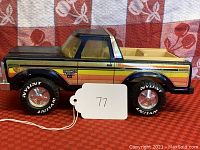 Side view of Nylint Ford Bronco Ranger XLT toy truck on red checkered tablecloth showing detailed decals and tire branding