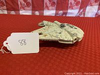 Side angled view of 6 inch Millennium Falcon toy showing top turret and detailing, slight paint wear visible.