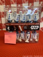 Front view of the boxed Disney Star Wars R2D2 Holiday Light Set showing ten individual R2D2 light figures arranged in two rows inside transparent packaging.
