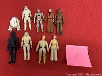 Full lot of ten Star Wars action figures on red cloth background.