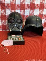 Front view of Darth Vader mask and helmet with voice distorter unit placed in front, showing overall condition and details