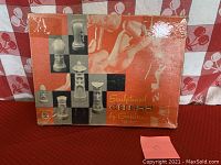 Photo of original box with vintage orange and white design and photographic images of chess pieces.