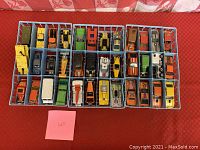 Photo of approximately 36 vintage Hot Wheels cars in a blue plastic display tray on red tablecloth