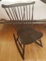 Side angled view showing solid wood seat with visible split and curved rockers