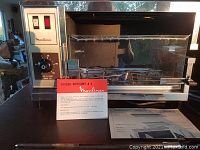 Front view of Moulinex Spit Roaster A5 Model 234 broiler rotisserie showing stainless steel body, control panel, glass door and included instructions.