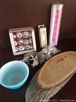 Full view of lot with blue Pyrex bowl, boxed shell napkin rings, metal fish napkin rings, pink candles, wooden cheese board