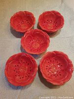 Five pink flower motif ceramic bowls arranged on a flat surface showing their size and shape.