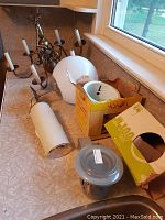 Photo showing antique brass chandelier, white globe lamp, metal heat lamp, wall sconce, and the boxed PAR 20 bulb.