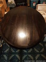 Top view of round black/brown painted wooden table surface showing finish and size
