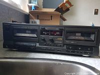 Front view of Technics RS-TR313 stereo double cassette deck showing two cassette compartments with auto reverse and control buttons below.