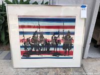 Framed woodcut art print showing riders on horses with a striped background, image taken front-facing to show entire framed piece and the hanging tag with lot number.