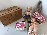 Overall lot showing three dolls, vintage boxes including 'Dolls', 'Toni Play Wave', and a pink cat/star box