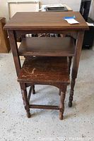 Overall view of stacked nesting tables showing both larger and smaller tables, with visible scratches on the smaller table surface.