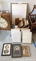 Wide view of the lot showing four white acrylic box frames and a larger metal acrylic frame along with other items.