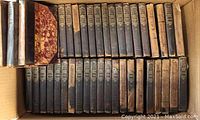 Full view of all 43 volumes of the Little Masterpieces series in worn condition inside a box.