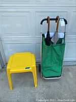 Shopping trolley, resin side table, and umbrellas shown together outside.