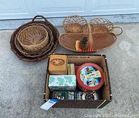 Overview of wicker baskets next to a box containing various tin containers and small boxes.