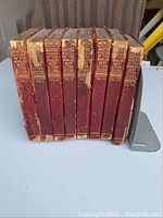 Eight volumes of Master Pieces of the Worlds Best Literature, red leather bindings, arranged side by side showing spines with titles and volume numbers