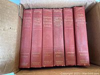 Six red hardcover Rudyard Kipling books, spines showing titles and Authorized Edition label, in a cardboard box.