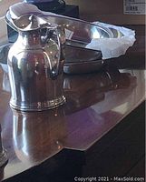 Stanley style stainless steel pitcher alongside two stacked stainless bowls