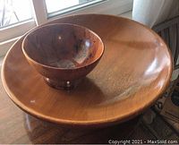 Both wooden bowls shown, large bowl with visible crack near rim, smaller darker bowl sitting inside