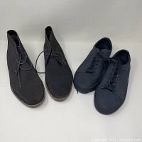 Pair of black Ben Sherman boots size 12 next to black Steve Madden sneakers size 10 on white background.