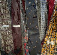 Photo showing multiple silk neck ties with various patterns and colors including designer labels Bill Blass and John Henry.