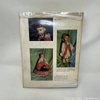 Back cover of the Collectors Encyclopedia of Dolls book showing three images of collectible dolls and some printed descriptive text.