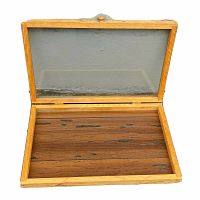 Open wooden display case with glass lid showing interior base with wood grain and natural wood frame.