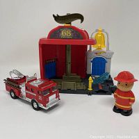 Photo of fire department playset with fire truck and firefighter figure arranged in front