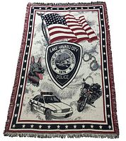 Front side of the woven blanket showing the Lake Havasu City Police emblem, American flag, police car, motorcycle, German Shepherd dog, and handcuffs.
