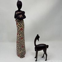 Full view of the mother figurine holding a baby with the deer sculpture next to her.