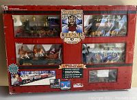 Front view of boxed Northpole Christmas Express animated train set showing engine, cars, reindeer sleigh inside package.