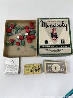 All game components including wooden pieces, money, cards, and box