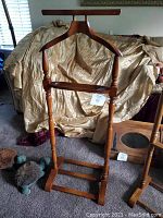 Front view of mid century wooden clothes valet showing hanger, tray and trouser bar