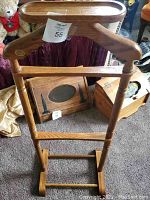 Full view of the midcentury solid oak clothes valet stand showing hanger, trouser bars, and sturdy base.