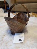 Front-side view of vintage metal bucket showing overall shape and handle