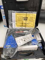 Mastercraft blue and silver air nailer inside black carrying case with manuals and instructions.